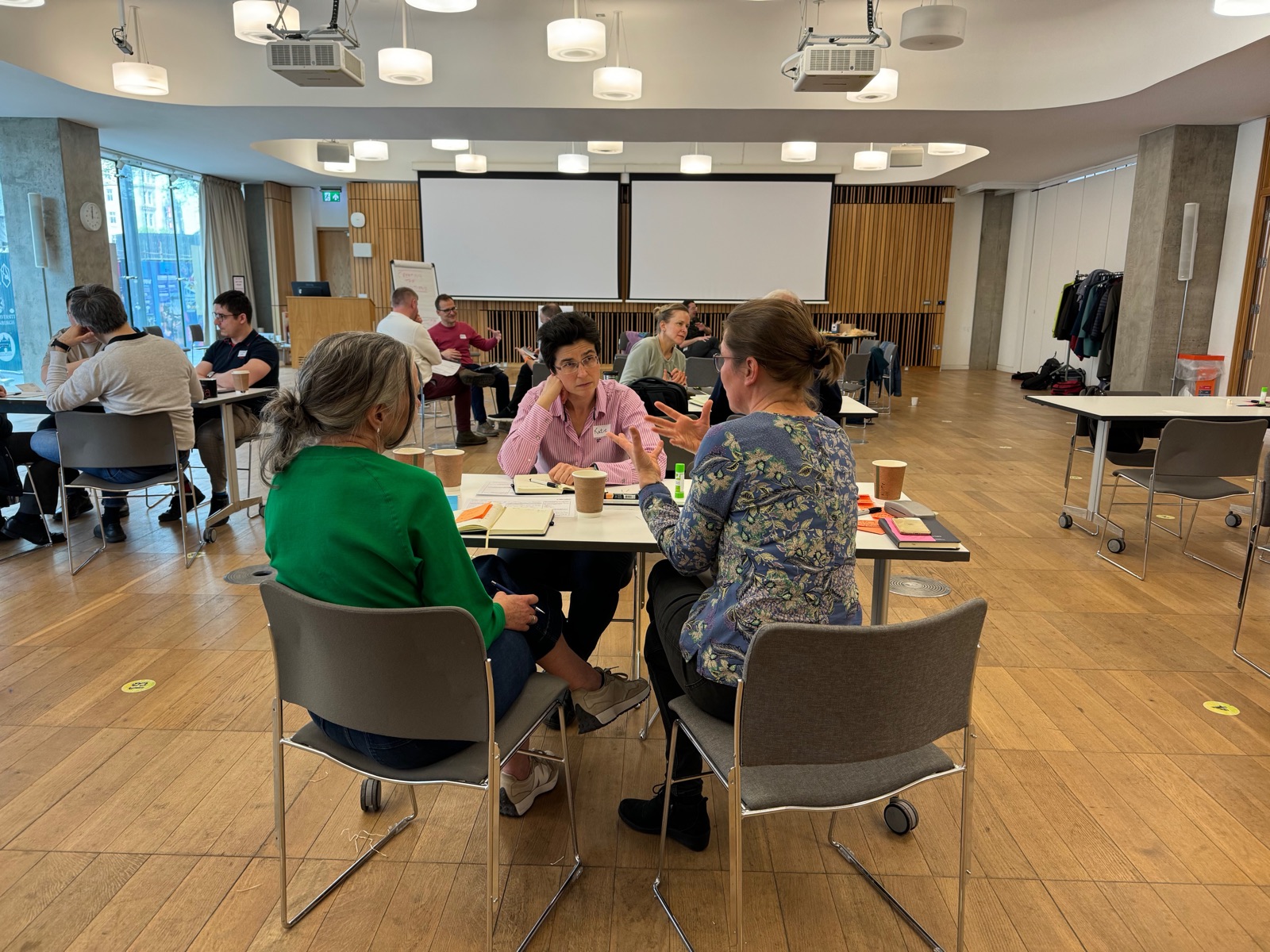 Participants working around tables in a workshop room